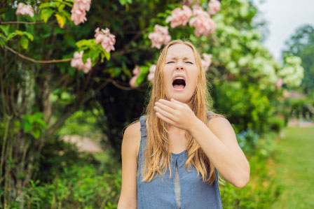 fille éternuant à l'extérieur à cause d'allergies