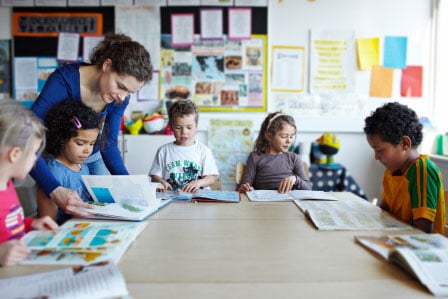 teacher helping children learn about arts & crafts